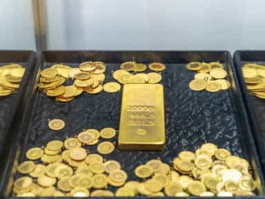 Gold prices slip as dollar firms, Trump eases Powell uncertainty